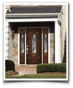 door3-e1627569214965 A stately brown wooden entry door with glass panels welcomes visitors amid elegant stone and white columns.