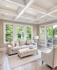 A sunlit living room with expansive windows creates an inviting, airy space that embraces the outdoors.