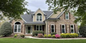 A welcoming suburban home stands amid a lush, carefully landscaped front yard.